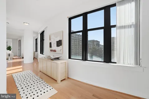 a view of a large room with wooden floor and windows