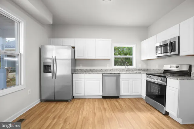 a kitchen with granite countertop a stove a sink and a refrigerator