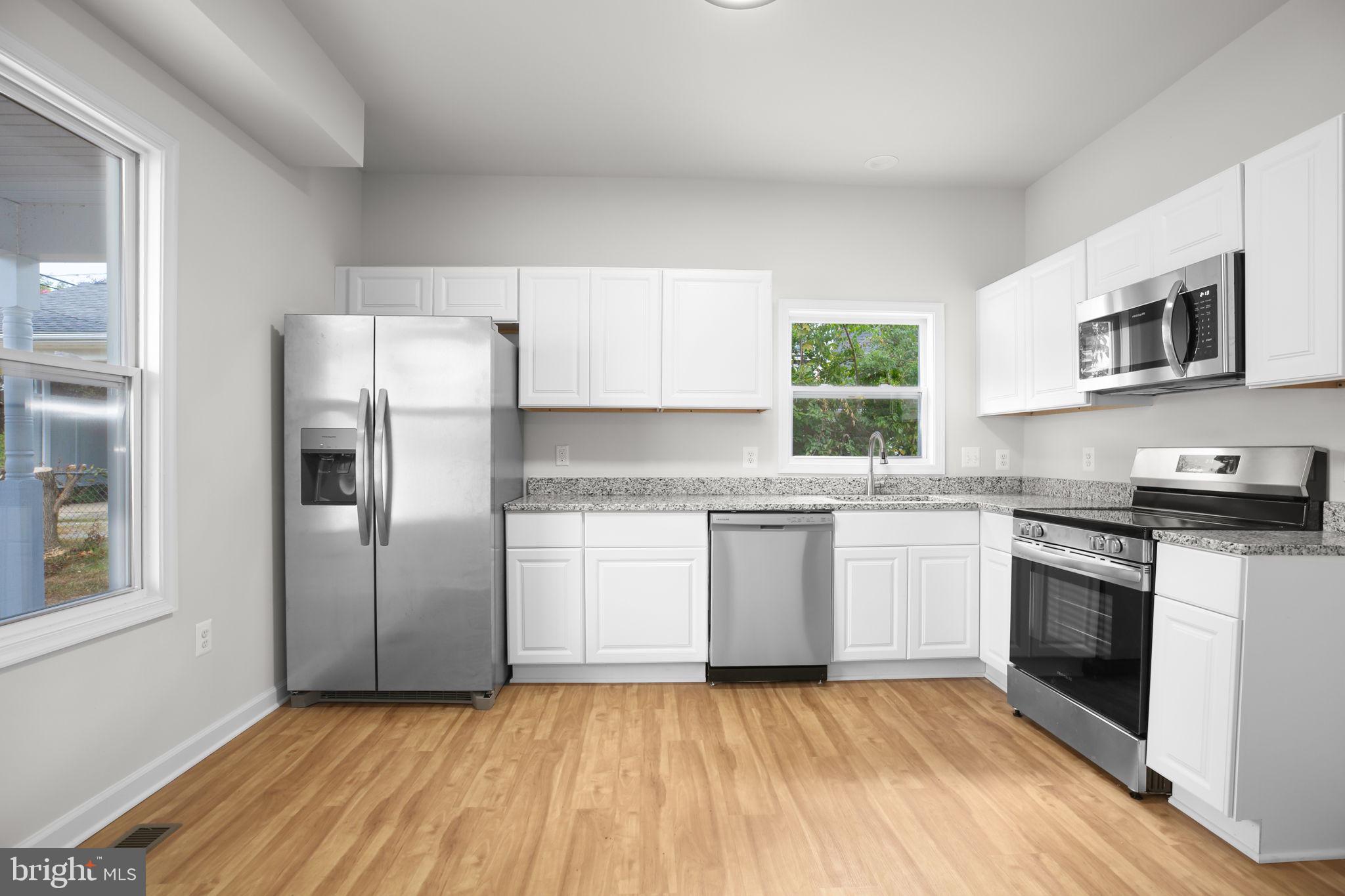 1424 William Street, Unit A Fredericksburg, VA 22401 - Photo 11 of 25 a kitchen with granite countertop a stove a sink and a refrigerator