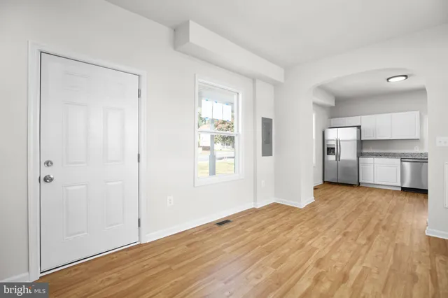 a view of empty room with wooden floor and window