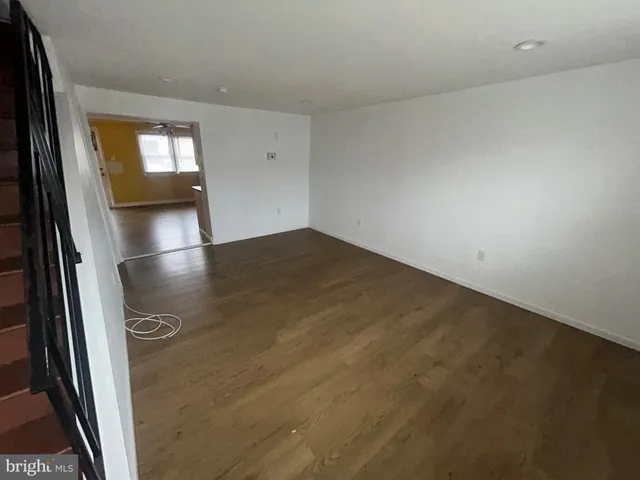 an empty room with wooden floor and mirror
