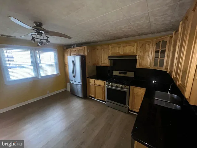 a kitchen with granite countertop a stove a sink and a microwave