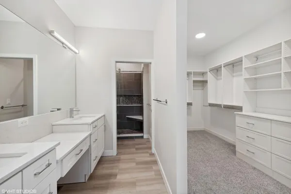 a bathroom with a double vanity sink a toilet and shower