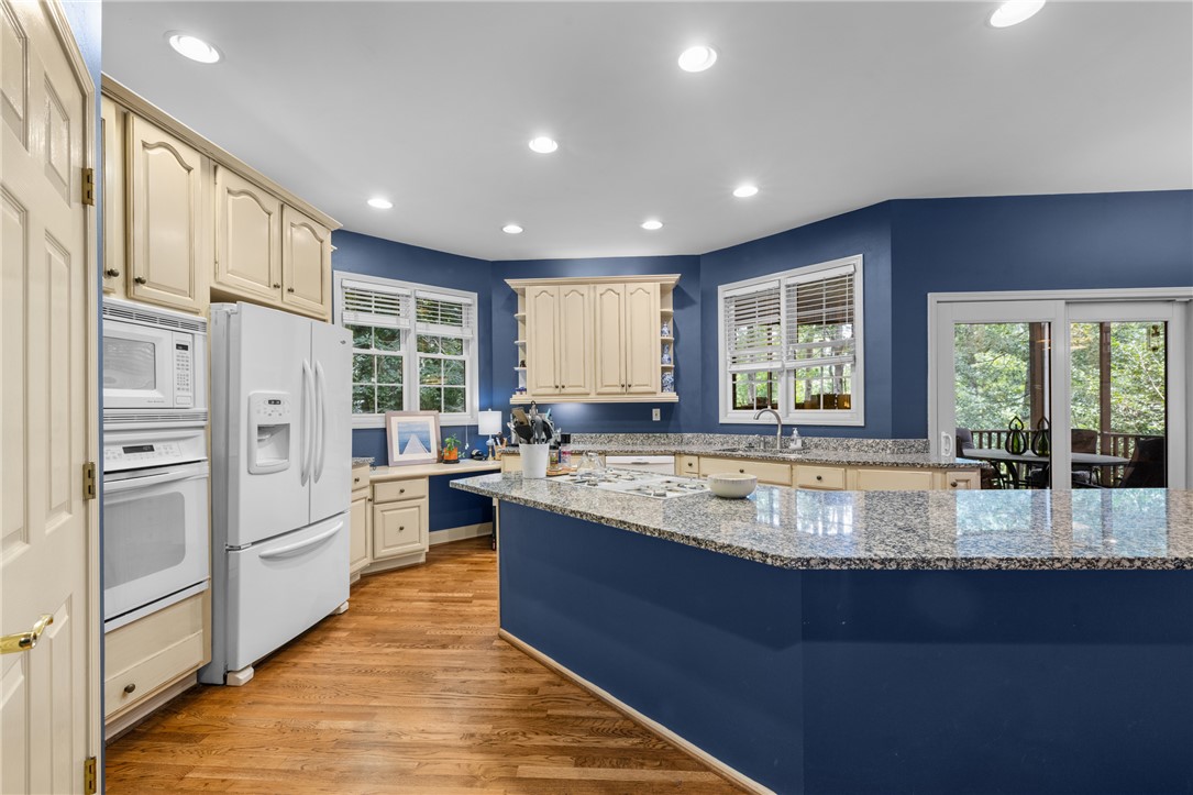 106 Red Maple Way Clemson, SC 29631 - Photo 14 of 49 Gleaming granite countertops pair beautifully with rich hardwood flooring in this spacious kitchen.