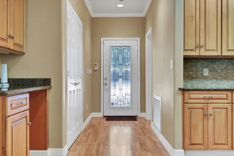 a view of hallway with granite countertop wooden cabinets