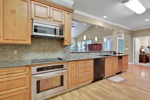 a kitchen with stainless steel appliances granite countertop a stove and cabinets