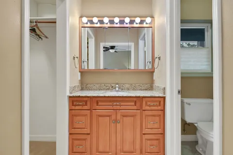 a bathroom with a granite countertop sink and a mirror