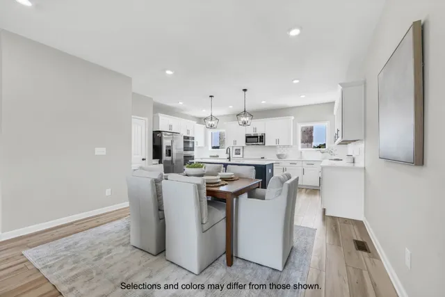 a kitchen with stainless steel appliances kitchen island granite countertop a sink a stove a refrigerator and white cabinets