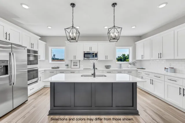 a kitchen with stainless steel appliances granite countertop a sink a stove a refrigerator cabinets and chairs