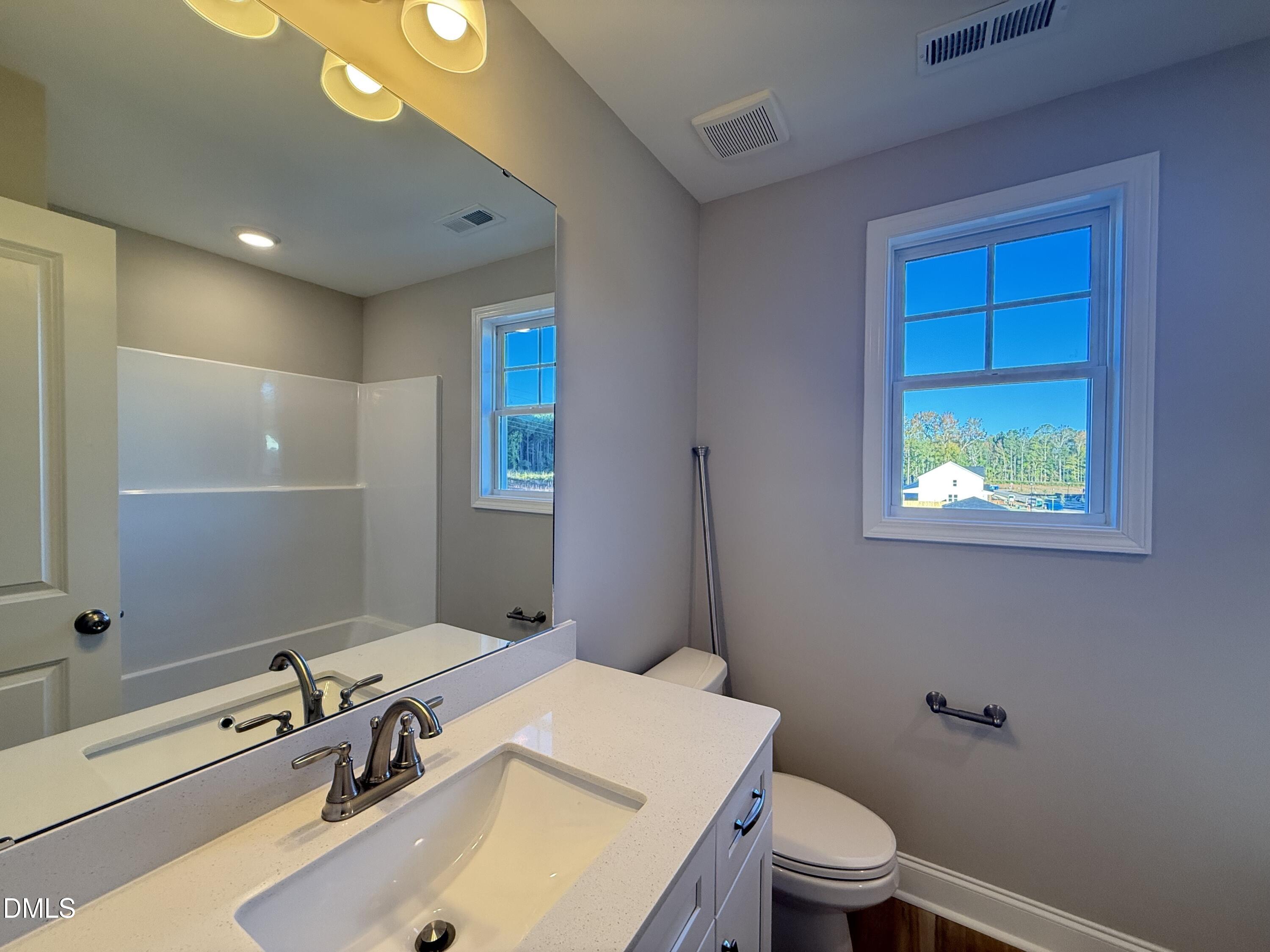 263 Bluejay Street Clayton, NC 27520 - Photo 13 of 22 a bathroom with a sink a toilet and shower