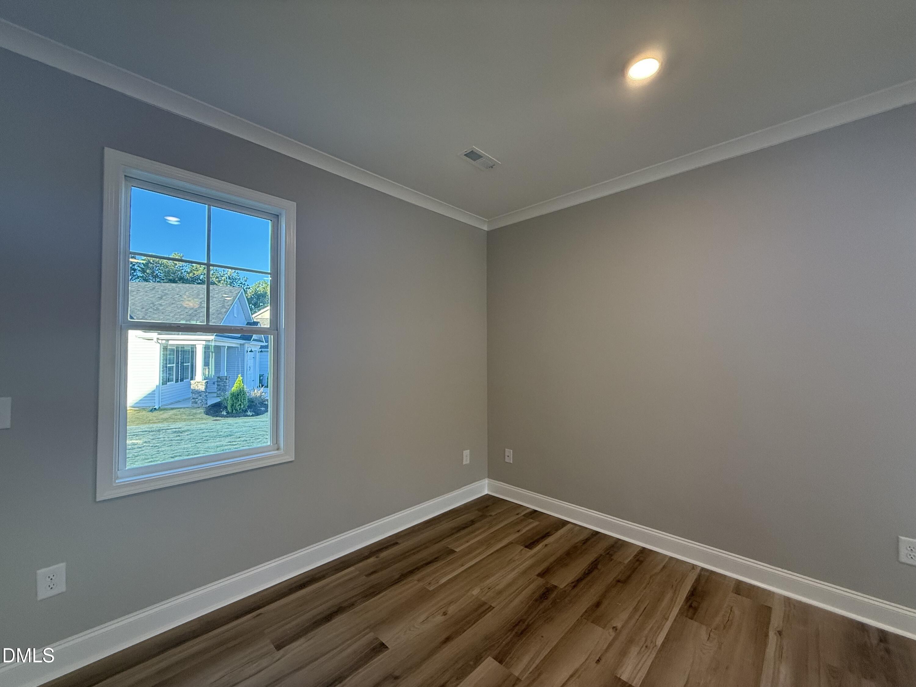 263 Bluejay Street Clayton, NC 27520 - Photo 4 of 22 an empty room with wooden floor and windows