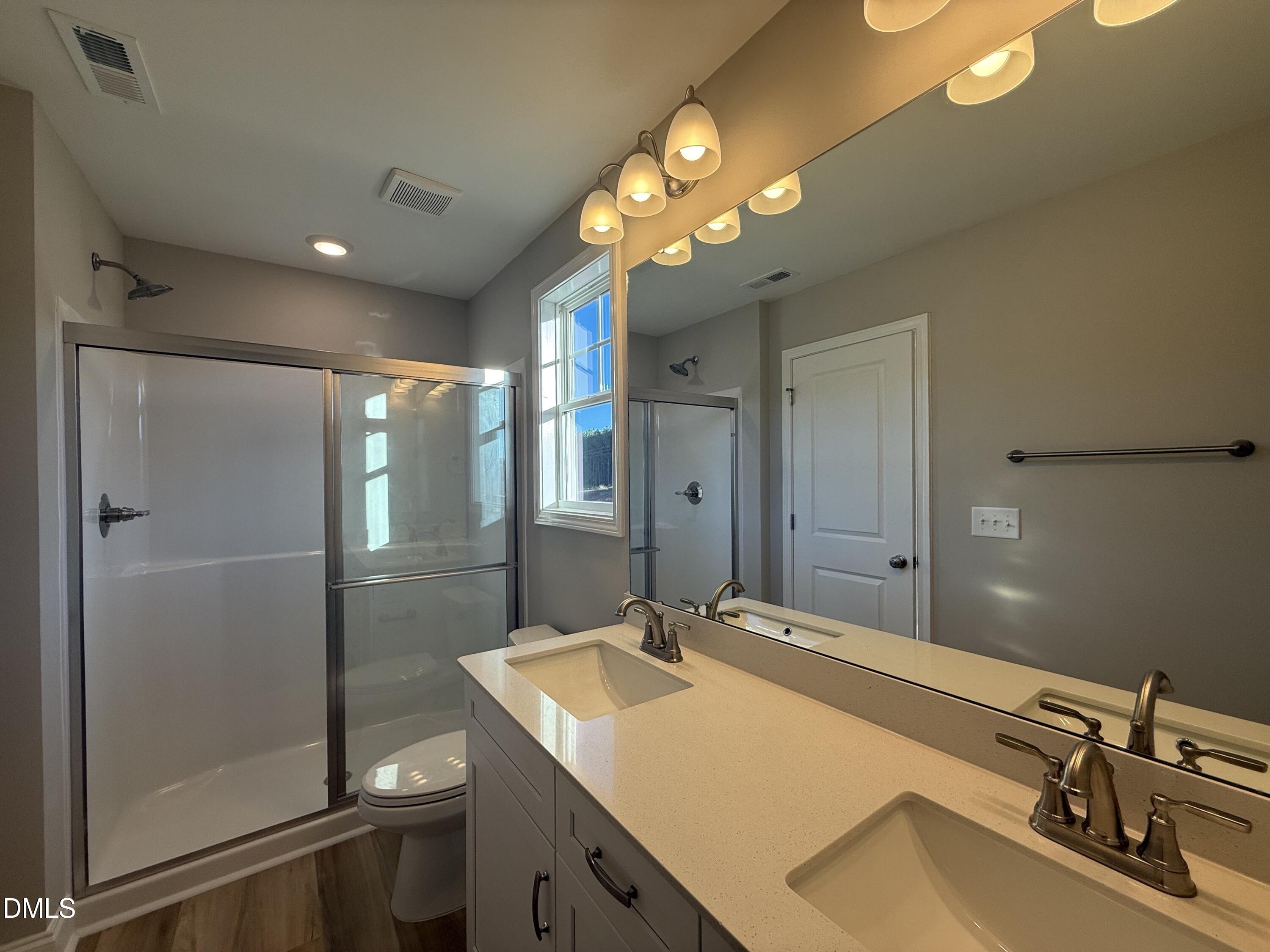 263 Bluejay Street Clayton, NC 27520 - Photo 9 of 22 a bathroom with a sink a light fixture and a mirror