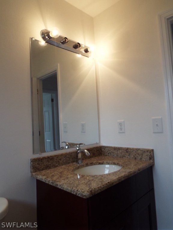 29 Andros Street Lehigh Acres, FL 33936 - Photo 9 of 16 a bathroom with a granite countertop sink and a mirror
