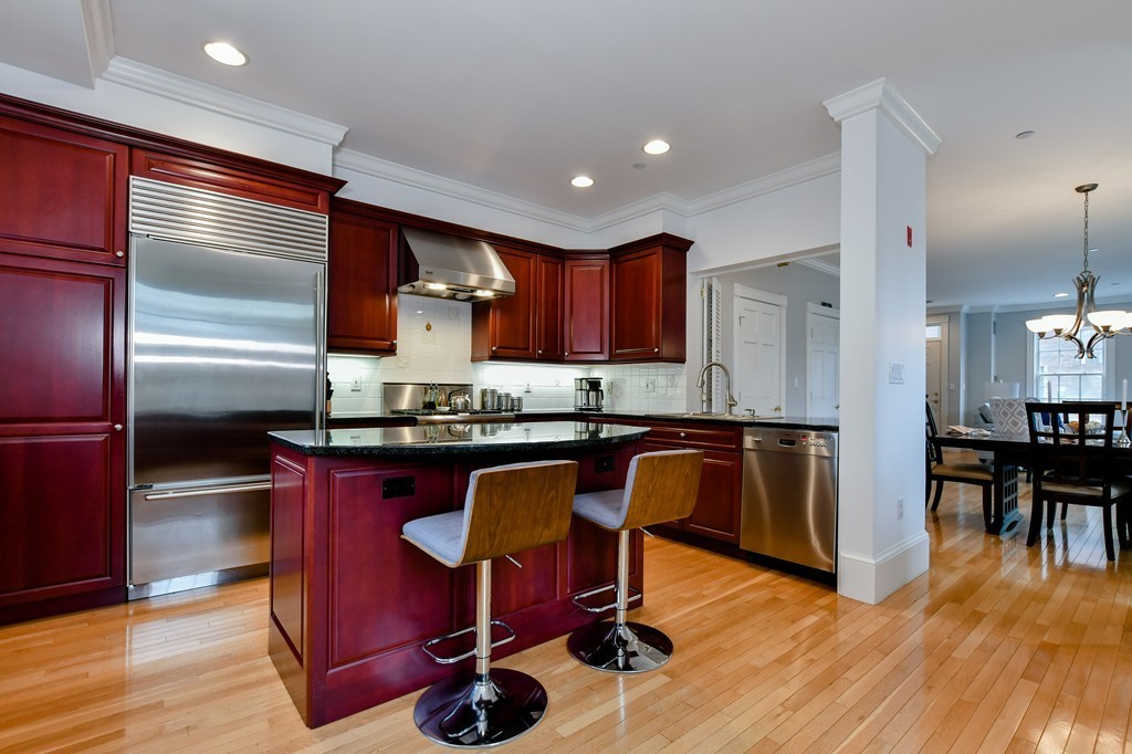90 Constitution Road, Unit 90 Boston, MA 02129 - Photo 11 of 29 a kitchen with granite countertop wooden floors and stainless steel appliances