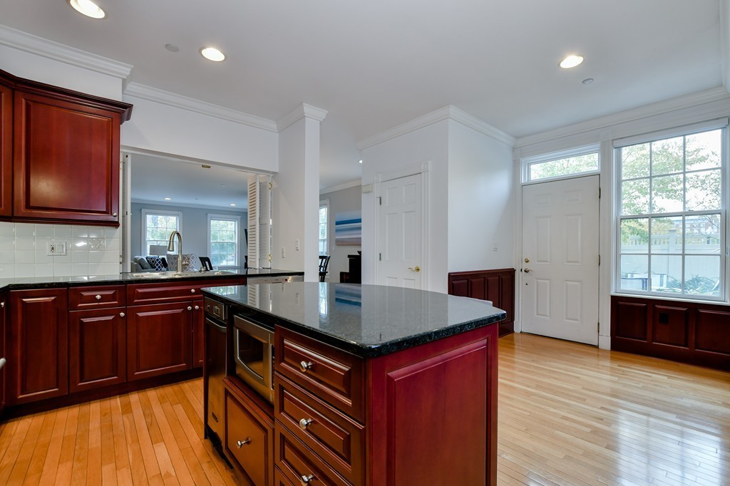 90 Constitution Road, Unit 90 Boston, MA 02129 - Photo 17 of 29 a kitchen with stainless steel appliances granite countertop wooden cabinets a stove a sink and a wooden floors