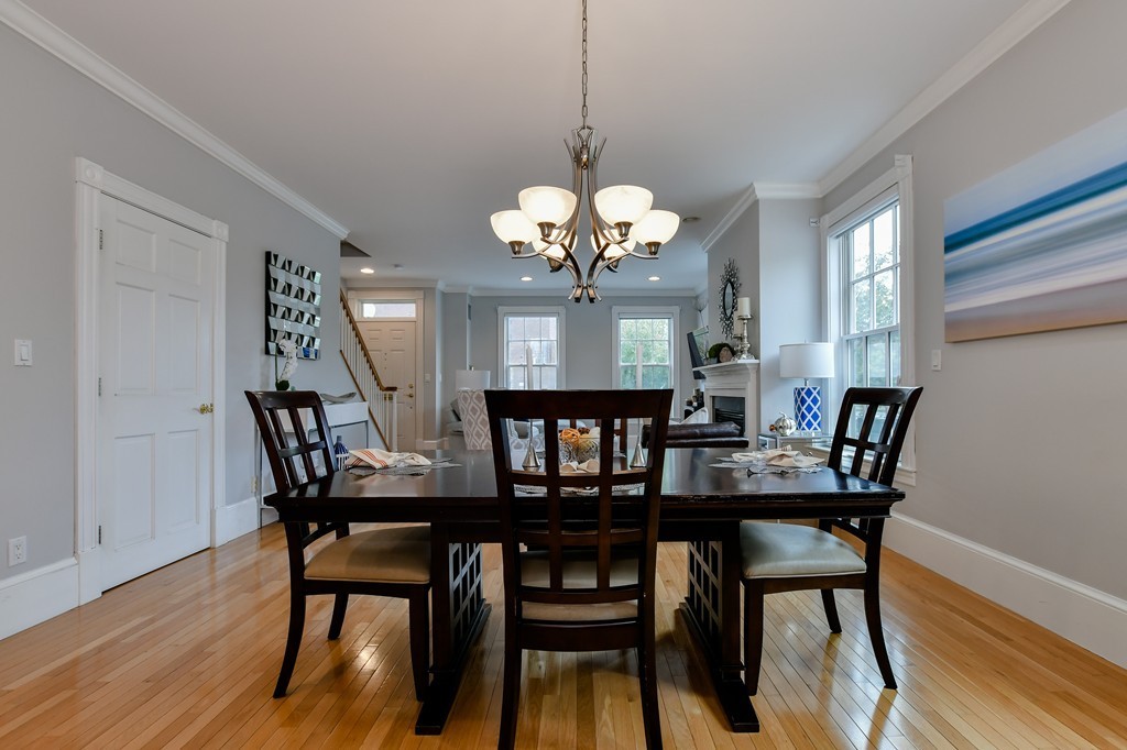 90 Constitution Road, Unit 90 Boston, MA 02129 - Photo 9 of 29 a dining room with wooden floor a chandelier a wooden table and chairs
