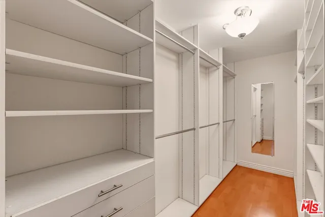 a view of walk in closet with empty racks