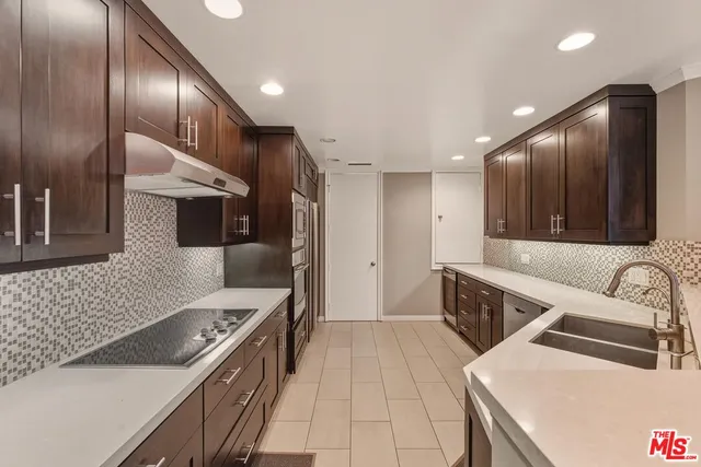 a kitchen with stainless steel appliances granite countertop a sink and a stove