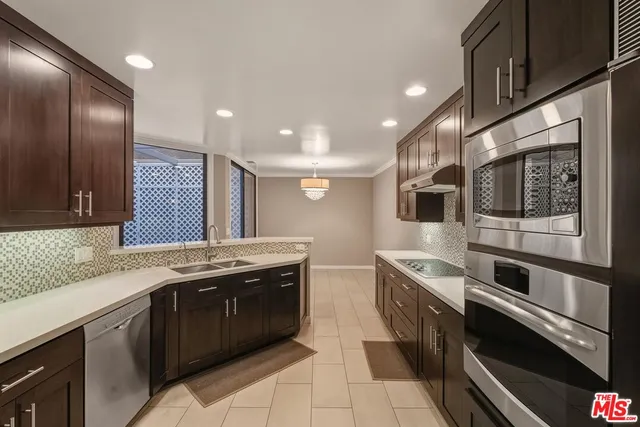 a kitchen with stainless steel appliances granite countertop a sink and a stove