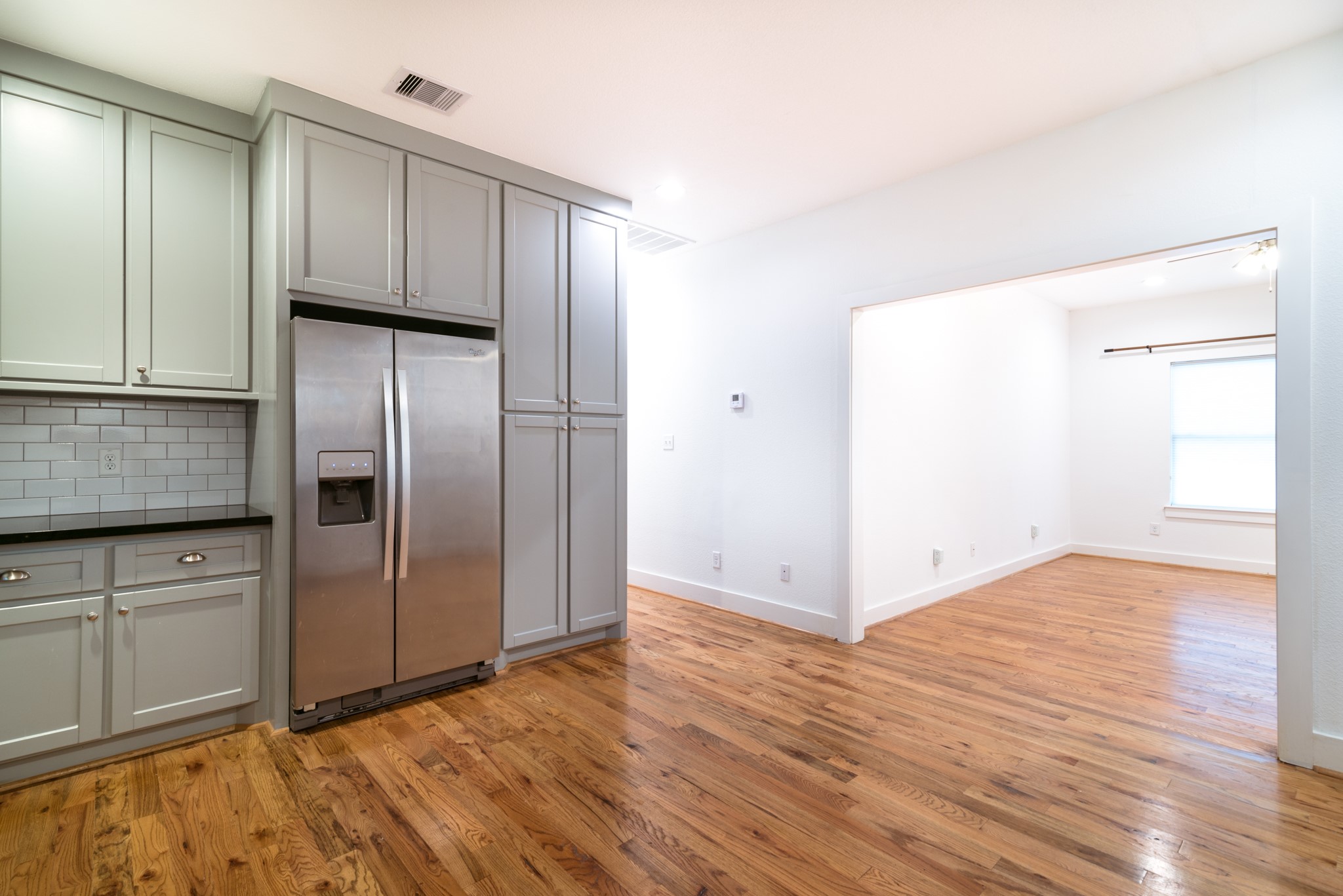 4734 Bell Street Houston, TX 77023 - Photo 11 of 42 a view of a refrigerator in kitchen and wooden floor