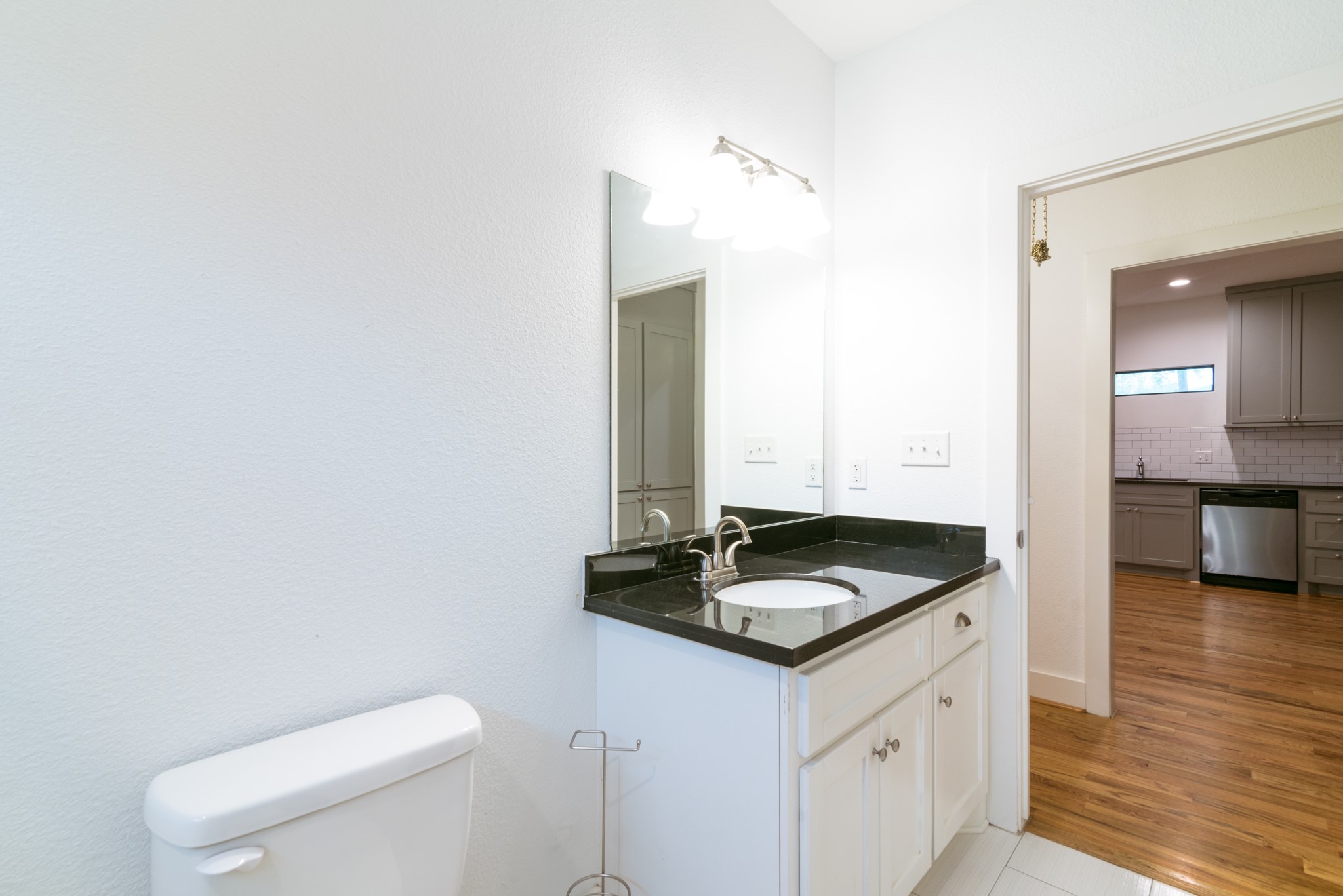 4734 Bell Street Houston, TX 77023 - Photo 15 of 42 a bathroom with a granite countertop sink and a toilet