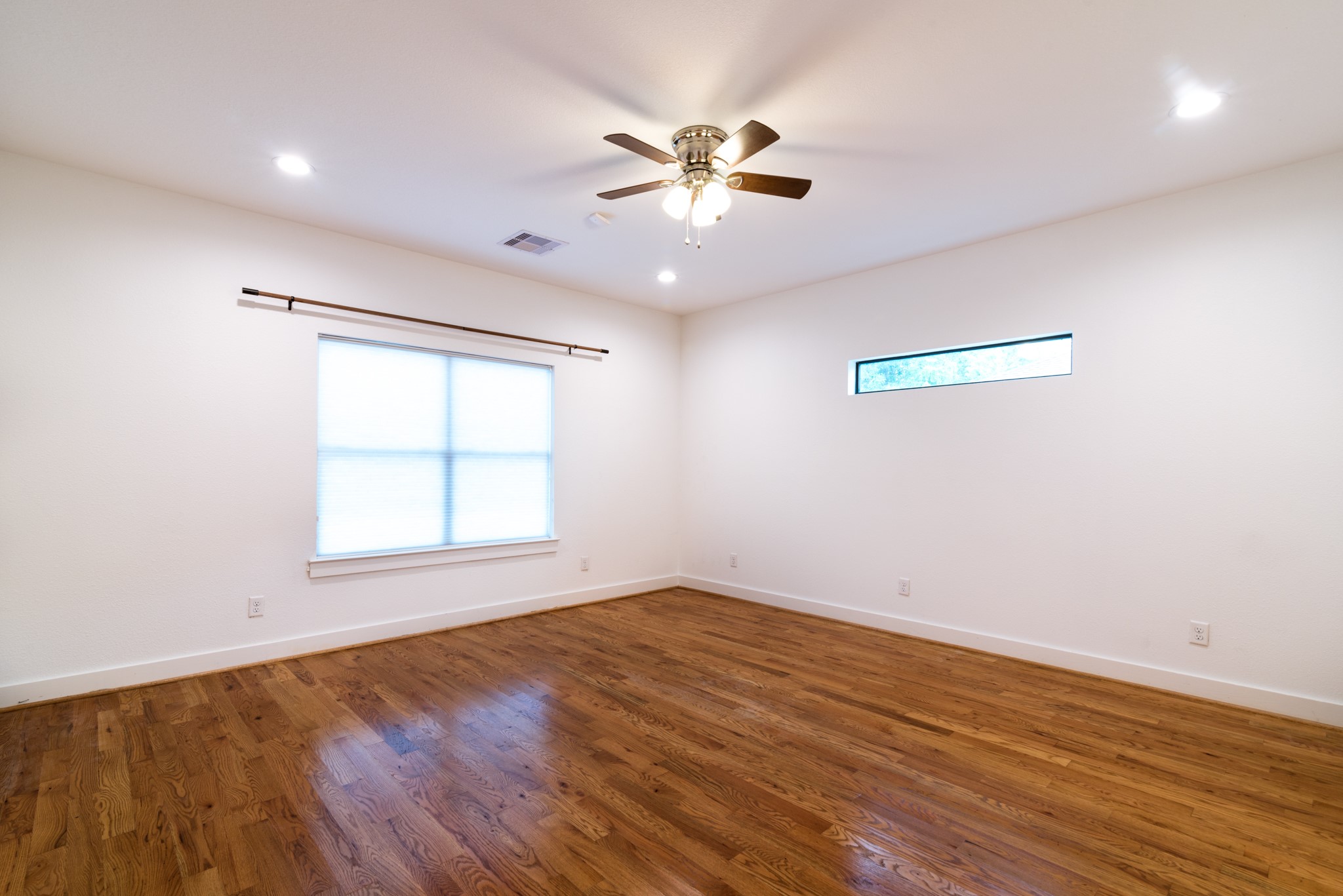4734 Bell Street Houston, TX 77023 - Photo 17 of 42 an empty room with wooden floor fan and windows