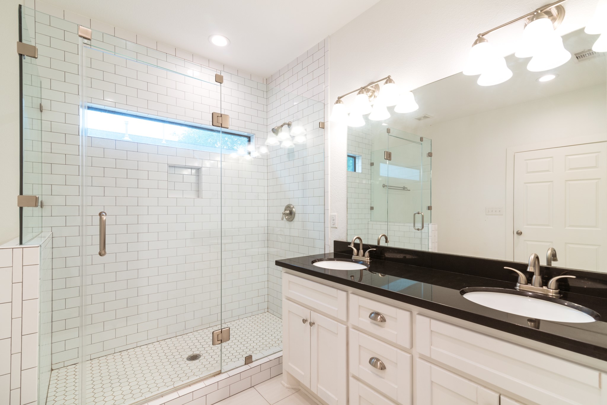 4734 Bell Street Houston, TX 77023 - Photo 18 of 42 a bathroom with a double vanity sink mirror and shower