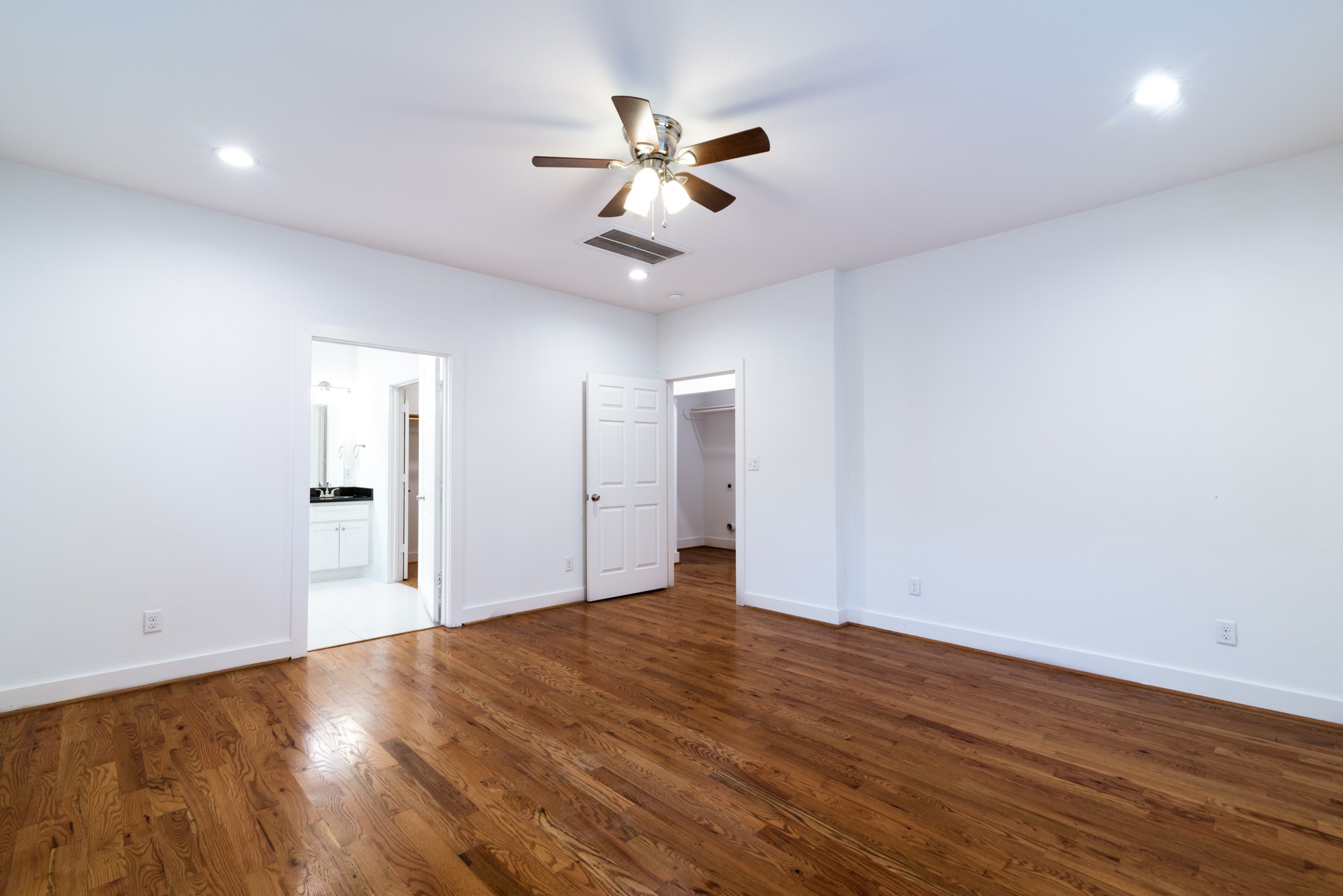 4734 Bell Street Houston, TX 77023 - Photo 41 of 42 an empty room with wooden floor ceiling fan and windows