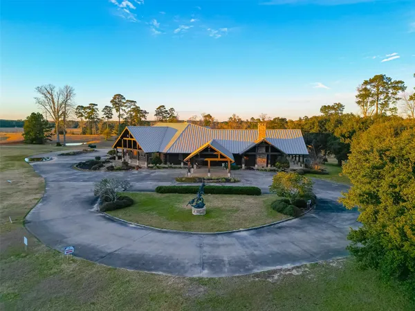 an aerial view of residential houses with outdoor space and trees