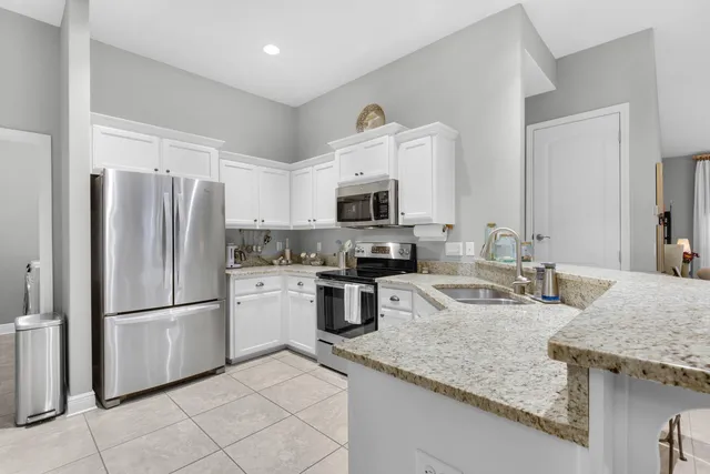 a kitchen with a granite countertop sink and white cabinets