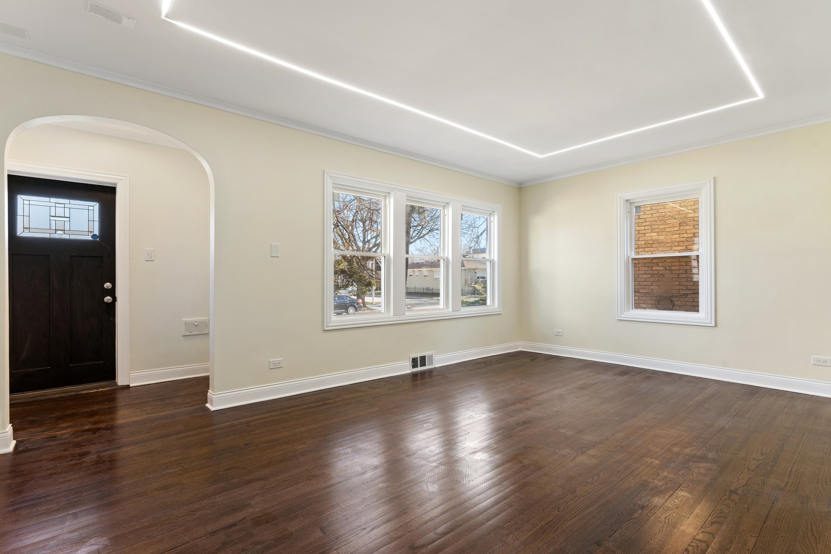 10954 South Normal Avenue Chicago, IL 60628 - Photo 5 of 17 an empty room with wooden floor and windows