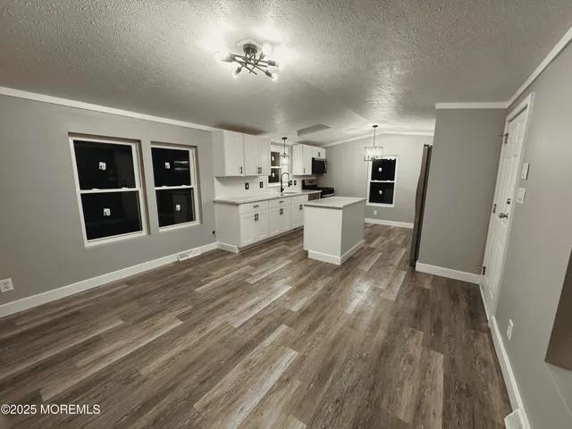a view of a kitchen with cabinets and wooden floor