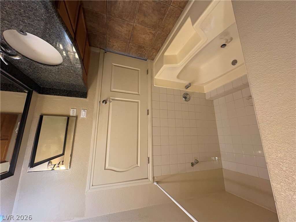 9325 West Desert Inn Road, Unit 123 Las Vegas, NV 89117 - Photo 24 of 36 A compact bathroom offers both a deep soaking tub and a functional shower area.