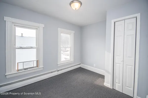 an empty room with windows and closet