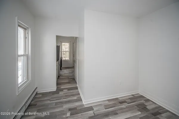 a view of a hallway with wooden floor and closet
