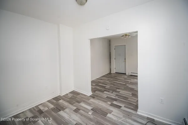 a view of a room with wooden floor and a ceiling fan