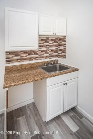 a view of kitchen with granite countertop cabinets