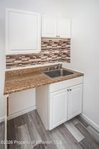 a view of kitchen with granite countertop cabinets