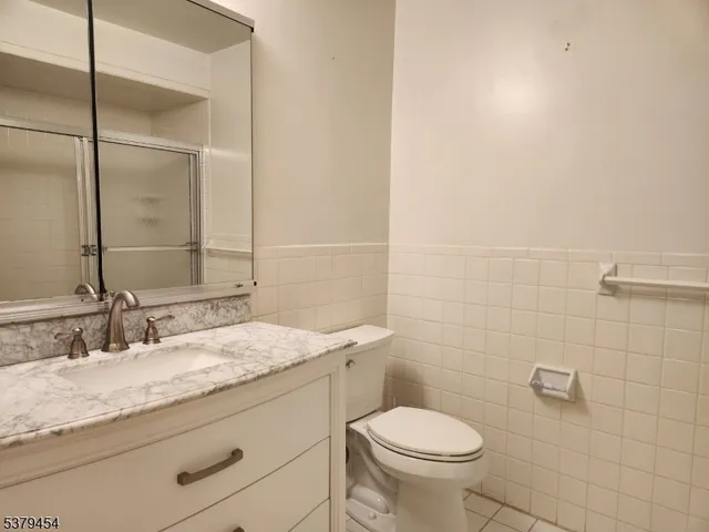 a bathroom with a granite countertop sink a toilet and a mirror