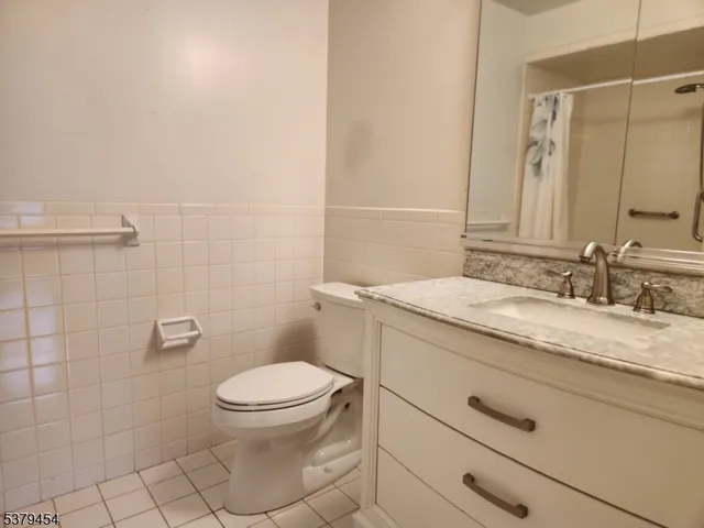 a bathroom with a granite countertop toilet a sink and a mirror