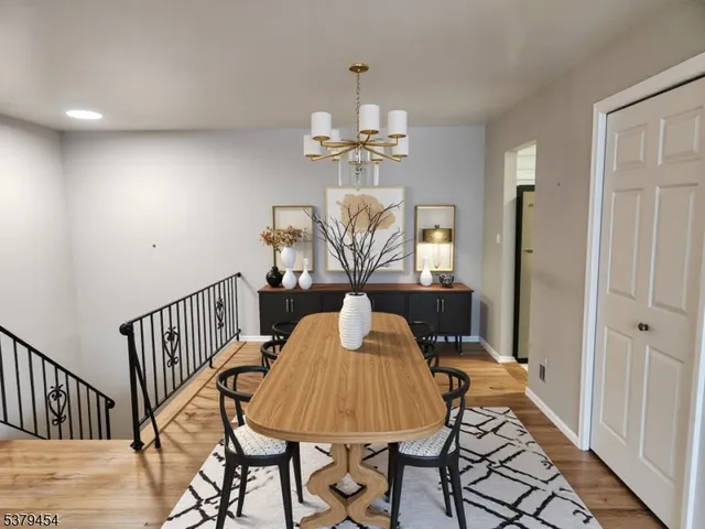 a view of a dining room with furniture a chandelier and wooden floor