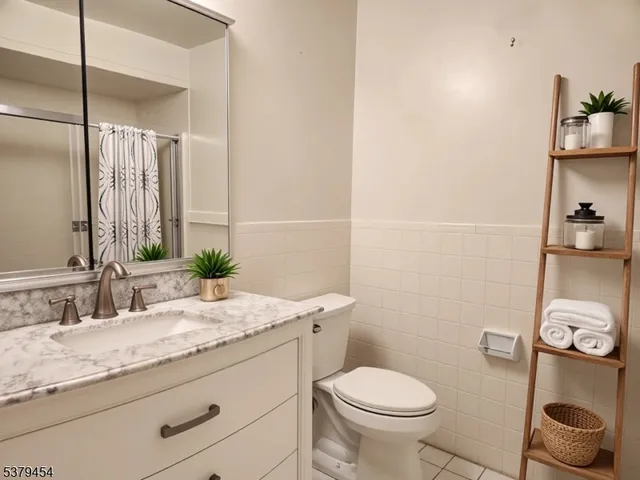 a bathroom with a granite countertop toilet sink and mirror