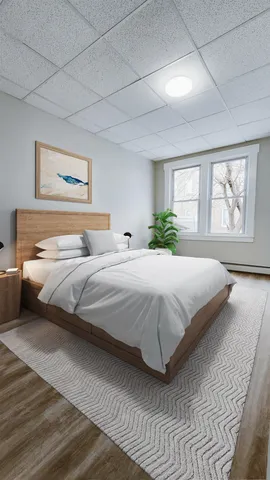 a bedroom with a bed and a painting on the wall