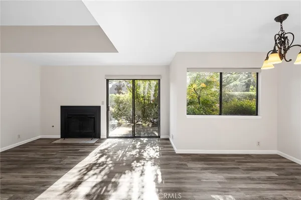 a view of an empty room with a fireplace and a window