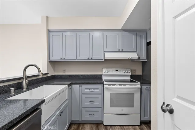 a kitchen with granite countertop white cabinets and white appliances