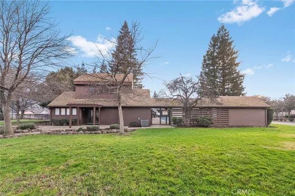 a view of a house with a big yard and large trees