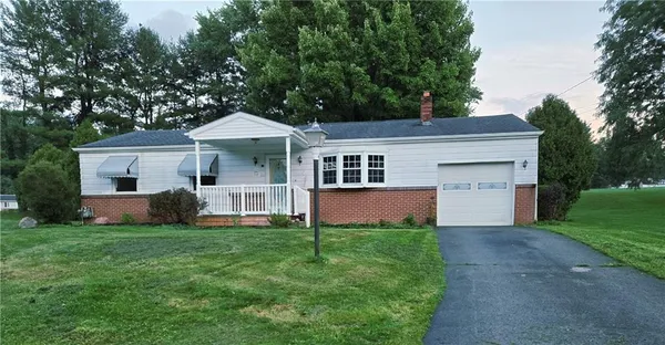 a front view of a house with a yard and trees