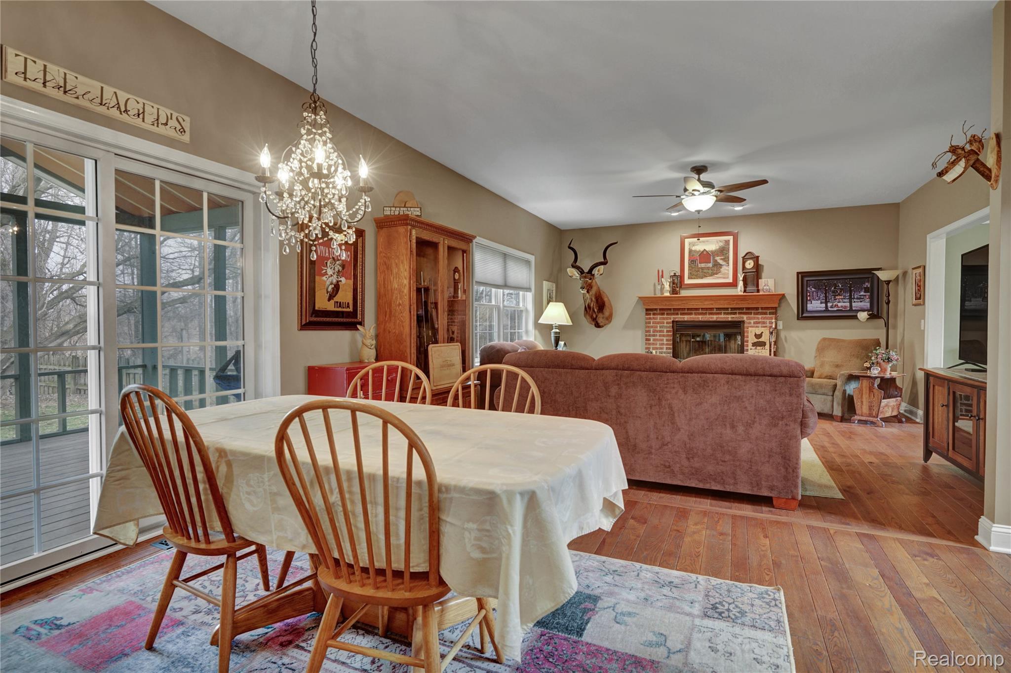 3690 Brauer Road Oxford, MI 48371 - Photo 16 of 63 Dining area featuring hardwood / wood-style floors, a brick fireplace, ceiling fan, and suspended lighting