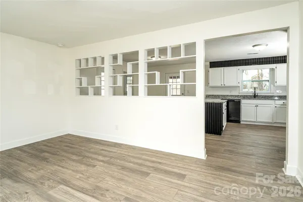 a view of a kitchen with wooden floor and cabinets