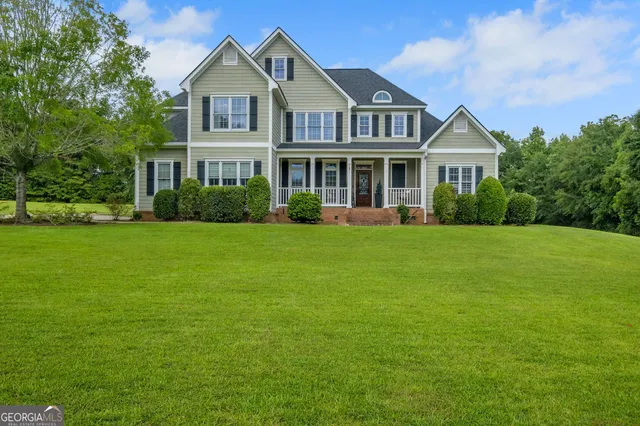 a front view of a house with a yard and green space